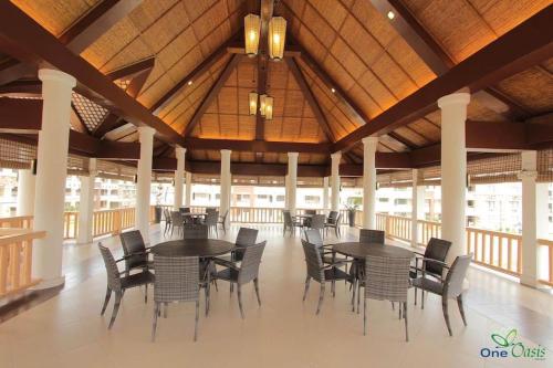 a dining area with tables and chairs in a building at Alles One Oasis Condo Davao Near SM Mall with Wifi in Davao City
