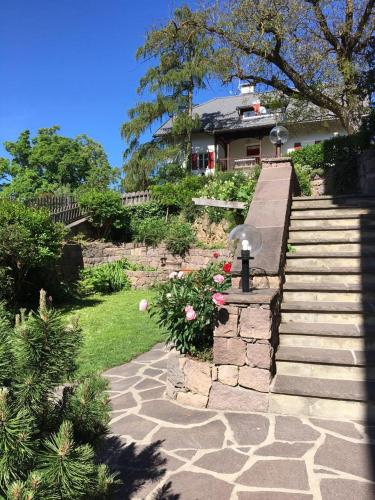 a garden with a staircase and a house with flowers at Apartments Garni Steffi in Fiè