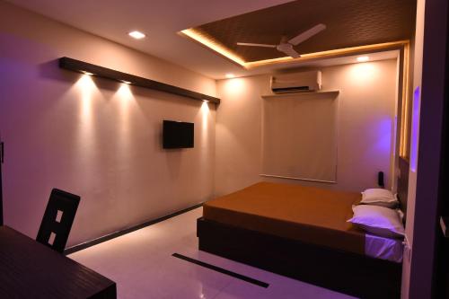 a room with a bed and a ceiling fan at Hotel Metro in Kumbakonam