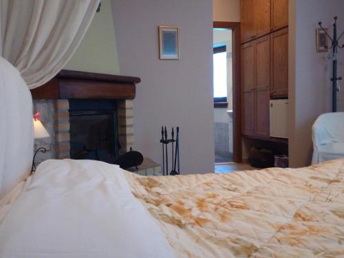 a bedroom with a large bed and a fireplace at Guesthouse Kalosorisma in Tsagarada