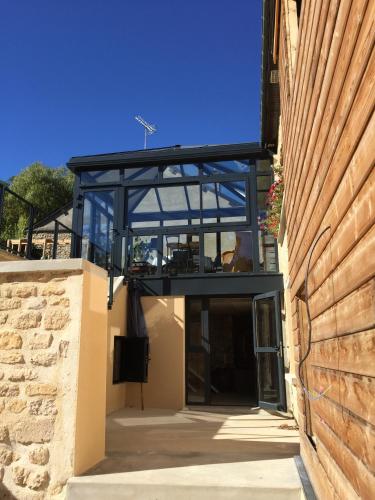 a house with a glass roof and a building at Gîte LES ARMINAUX in Remilly-les-Pothées