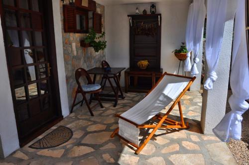 a room with a chair and a table and a door at Tvrdic Honey in Grohote