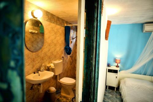 a bathroom with a sink and a toilet and a bed at Tvrdic Honey in Grohote