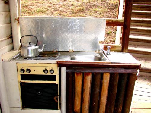 an outdoor kitchen with a sink and a stove at Hindthausen in Knysna