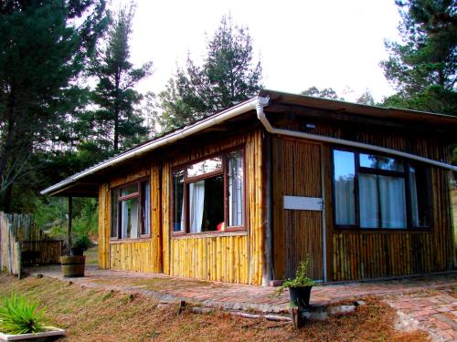 a small wooden cabin with a large window at Hindthausen in Knysna