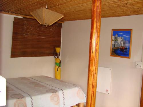 a small bedroom with a bed and a window at Hindthausen in Knysna