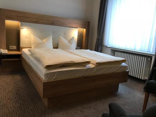 a bedroom with a large bed with white pillows at Weinhotel Römerbad in Bad Salzuflen