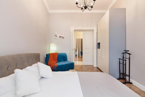 リヴィウにあるChopin Apartment in the center of Lvivのベッドルーム1室(ベッド1台、青い椅子付)