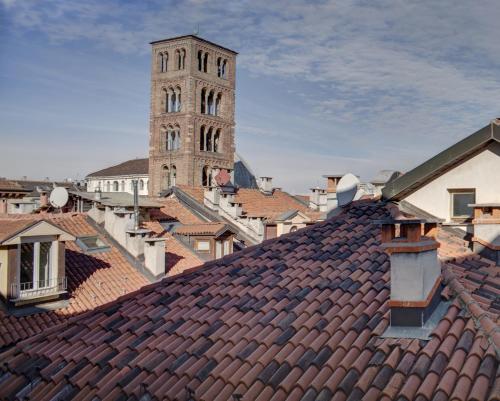 a clock tower in a city with roofs at QUADRATO in Turin