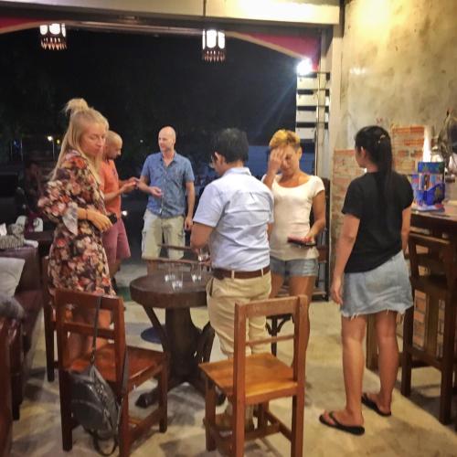 a group of people standing around a table at OK CHIC PHUKET HOSTEL in Phuket Town