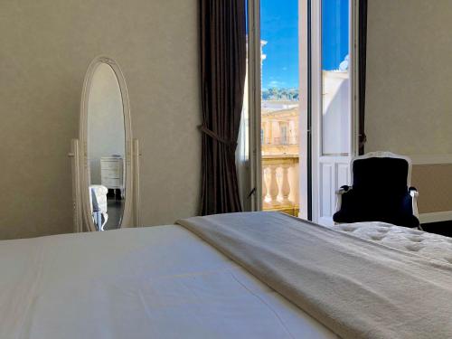 a bedroom with a large bed and a large window at Palazzo Favacchio - Patanè in Scicli