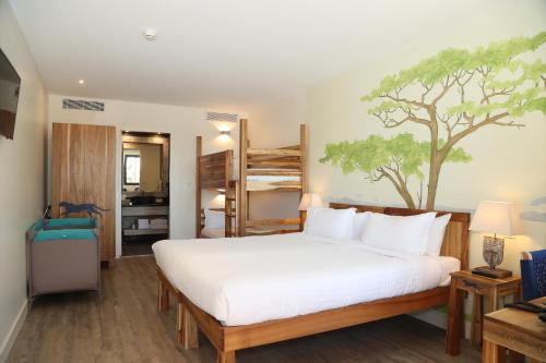 a bedroom with a bed with a tree mural on the wall at Les Hauts de Beauval in Saint-Aignan