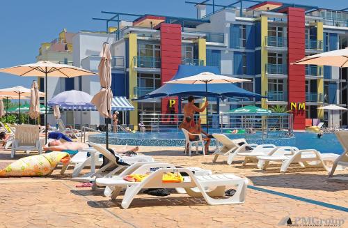 un grupo de sillas y sombrillas junto a una piscina en Elit 4 Apartments, en Sunny Beach