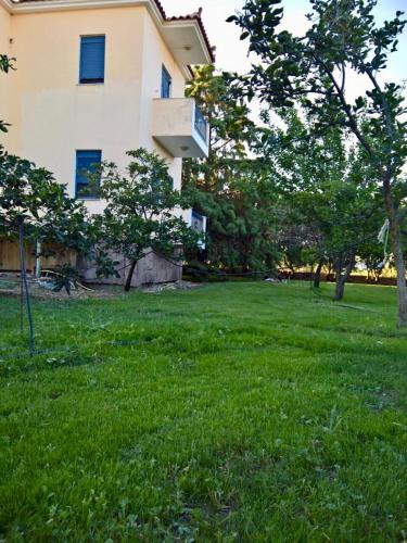a building in a field of green grass with trees at Villa Marita in Lisvórion