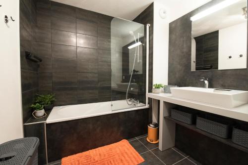 a bathroom with a bath tub and a sink at T4 8 personnes de grand standing classé 4 étoiles en plein centre de Saint Lary Soulan in Saint-Lary-Soulan