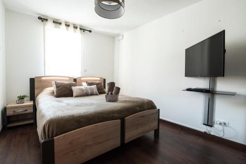 a bedroom with a bed and a flat screen tv at T4 8 personnes de grand standing classé 4 étoiles en plein centre de Saint Lary Soulan in Saint-Lary-Soulan