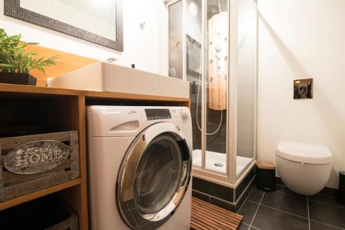a washing machine in a bathroom with a toilet at T4 8 personnes de grand standing classé 4 étoiles en plein centre de Saint Lary Soulan in Saint-Lary-Soulan