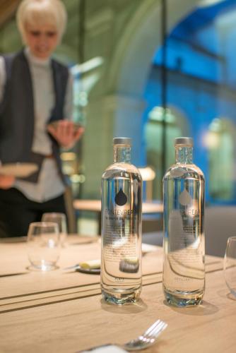 two glass bottles sitting on top of a table at Fontevraud L'Ermitage in Fontevraud-l'Abbaye