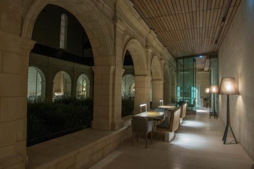 a hallway with a table and chairs in a building at Fontevraud L'Ermitage in Fontevraud-l'Abbaye