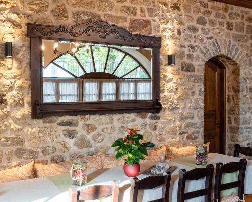 a table with a vase of flowers on top of a stone wall at Kaza Guesthouse in Dhimitsana