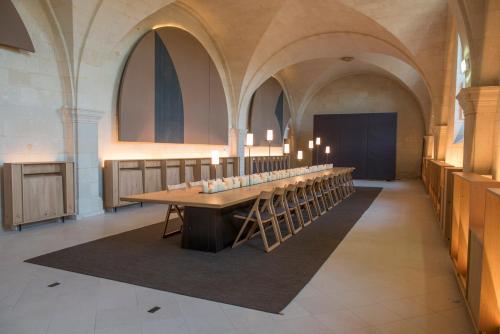 a long table in a church with candles on it at Fontevraud L'Ermitage in Fontevraud-l'Abbaye