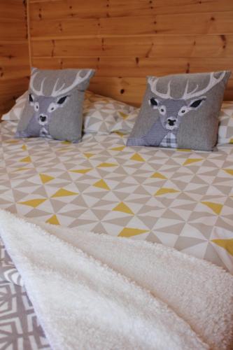 two beds with pillows and pillows on them at Howe of Torbeg in Ballater