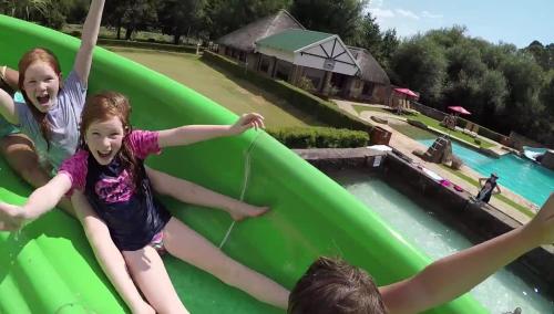 a group of kids on a inflatable slide at a water park at Gooderson Drakensberg Gardens Golf & Spa Resort in Drakensberg Garden