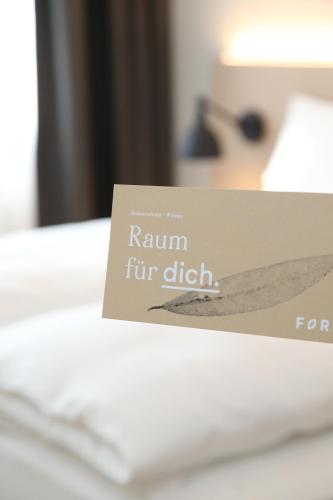 a sign sitting on top of a bed at Businesshotel Forum Widnau in Widnau