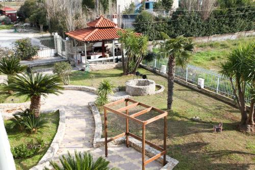 a park with palm trees and a fountain and a building at The Villa of the Winds in Néa Kíos