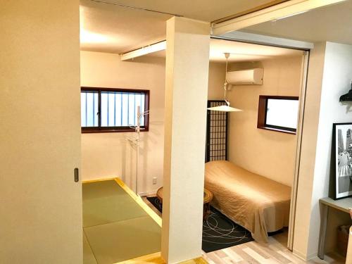 a room with a bed and a room with a door at Den７【1F&2F】Shirokane Takanawa Apts in Tokyo