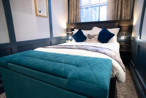 ein Schlafzimmer mit einem großen Bett mit einer blauen Decke in der Unterkunft Blackbird in London
