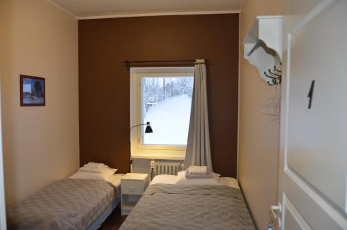 two beds in a room with a window at Imatran Portti in Imatra