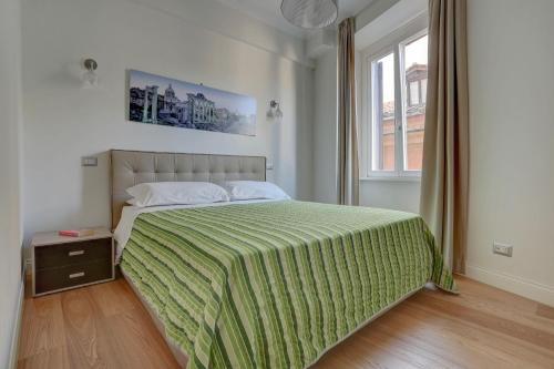 a bedroom with a large bed with a green blanket at La Casa Sui Fori in Rome