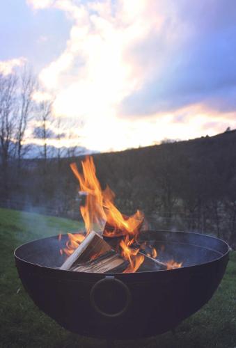 a fire pit with fire in it in the grass at Howe of Torbeg in Ballater