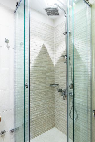 a shower with a glass door in a bathroom at Kaza Guesthouse in Dhimitsana