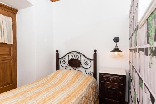 a bedroom with a bed and a wooden dresser at Kaza Guesthouse in Dhimitsana