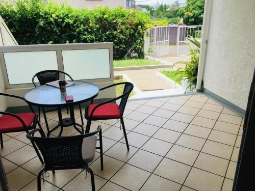a patio with a table and chairs on a patio at Les Gentilhommieres Guest House in Trou aux Biches