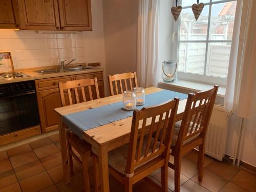 a kitchen with a wooden table with chairs and a window at Ferienhof Utech in Wenkendorf auf Fehmarn
