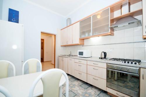 a kitchen with white cabinets and a stove at Cheap Apartments in Kyiv