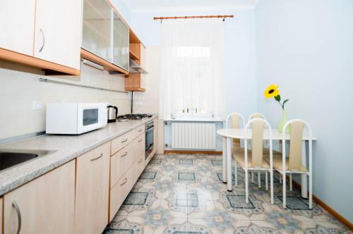 a kitchen with a table and chairs and a microwave at Cheap Apartments in Kyiv