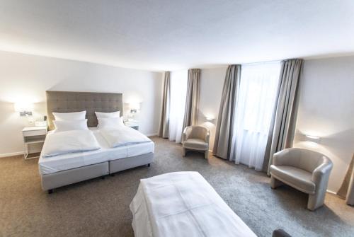 een hotelkamer met een bed en een stoel bij Bayerischer Hof in Kitzingen