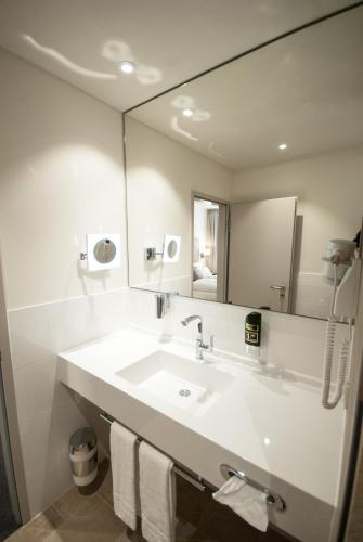 a bathroom with a sink and a large mirror at Bayerischer Hof in Kitzingen