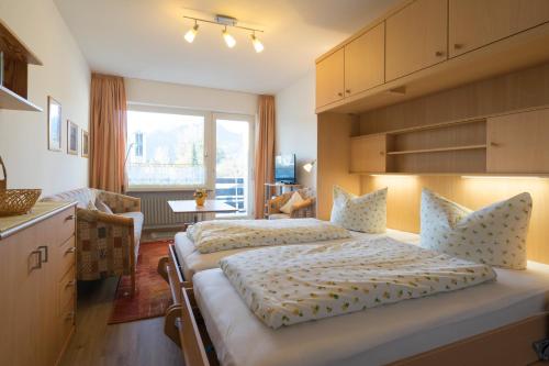1 dormitorio con 2 camas y cocina con ventana en Allgäuhaus, en Oberstdorf