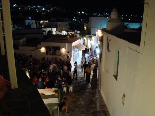a crowd of people walking down a street at night at Avra Guestroom in Apollonia