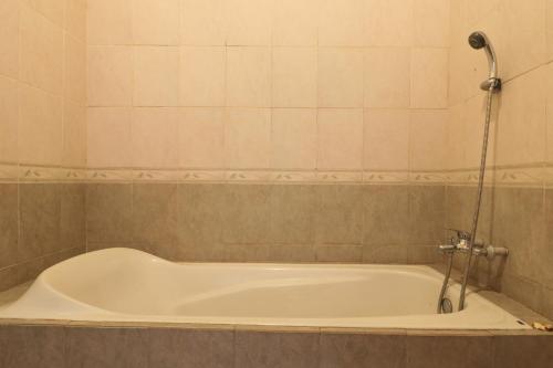 a bath tub with a shower in a bathroom at Rahayu House Ubud in Ubud