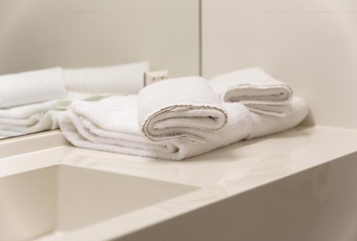 stos ręczników siedzących na ladzie w łazience w obiekcie Jugendgästehaus Brigittenau &Brigittenau Youth Palace w Wiedniu