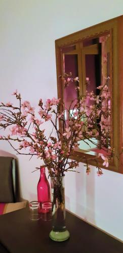 a vase with pink flowers in it on a table at Ashram Villa Sunshine in Sitges