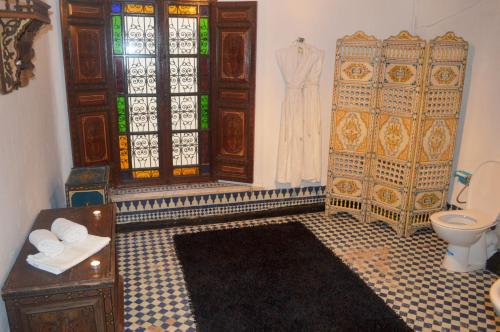 a bathroom with a toilet and a stained glass window at Palais AL Firdaous in Fès
