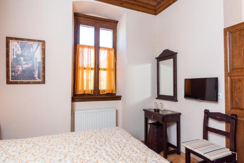 a bedroom with a bed and a mirror and a chair at Kaza Guesthouse in Dhimitsana