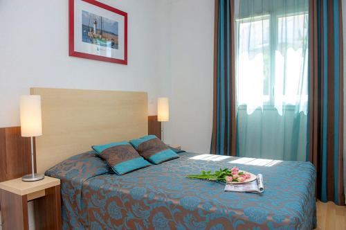 a bedroom with a bed with a tray of flowers on it at Résidence Goélia La Grande Plage in Saint-Gilles-Croix-de-Vie